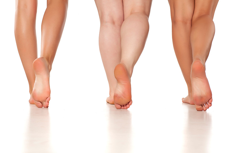 the underside of the right foot of three people standing side-by-side