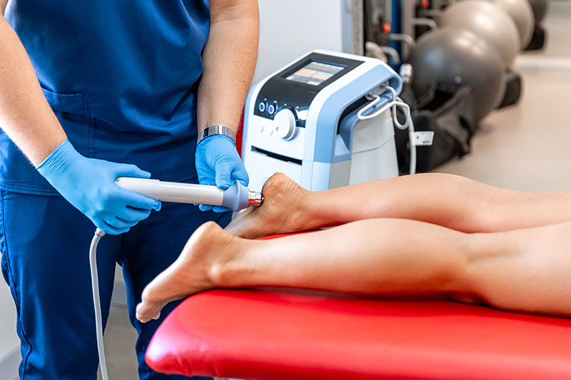 physician applying laser therapy to a patient's heel