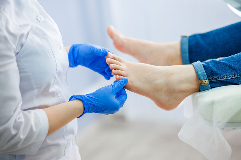 physician looking at a patient's toes