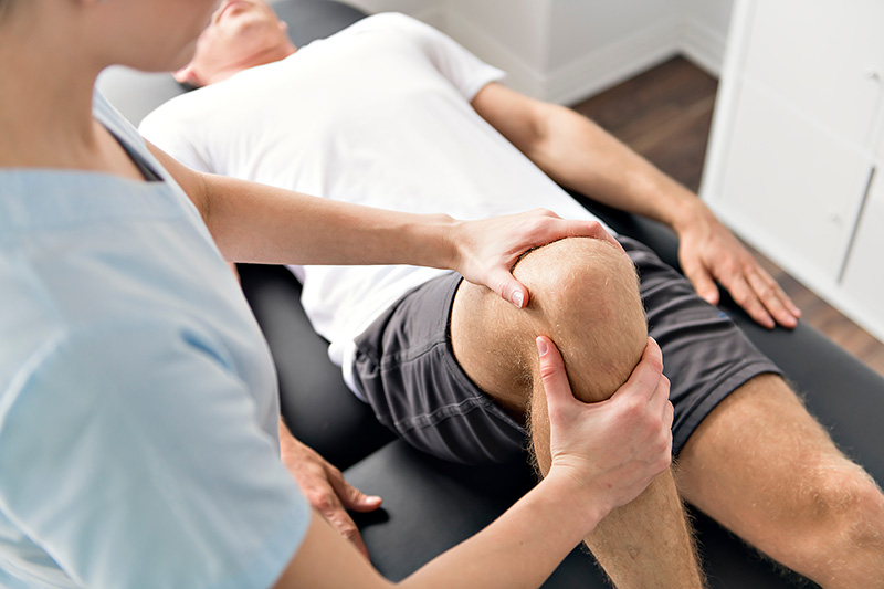 physician assessing a patient's knee